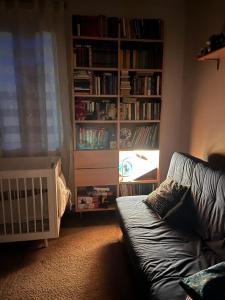 a living room with a couch and a book shelf at Casa del bosque in Upesciems