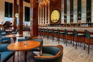 restauracja ze stołami i krzesłami oraz bar w obiekcie Sheraton Hannover Pelikan Hotel w Hanowerze
