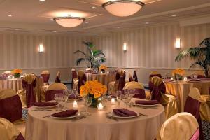ein Bankettraum mit Tischen und Stühlen mit Blumen darauf in der Unterkunft Four Points by Sheraton Wakefield Boston Hotel & Conference Center in Wakefield