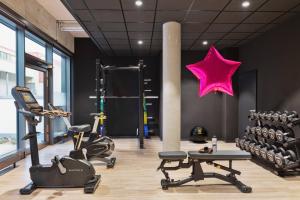 a gym with exercise equipment and a star on the wall at Moxy Hamburg Altona in Hamburg