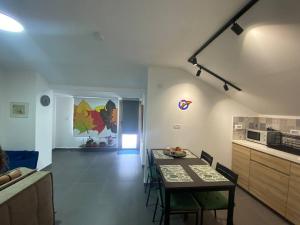 een woonkamer met een tafel en een keuken bij קומותיים ברמה in Sha'al