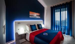 una camera con letto e parete blu di Riviera Del Sole Hotel Resort Spa a Piraino