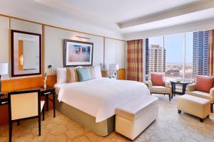 a bedroom with a large bed and a living room at Ritz Carlton Residences DIFC Downtown Dubai in Dubai