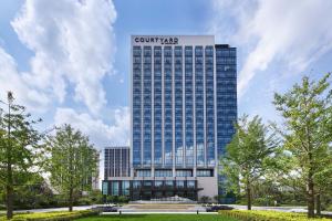 un edificio alto con un cartel encima en Courtyard by Marriott Changchun, en Changchún