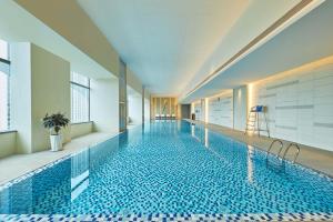 a swimming pool with a tile floor in a building at Courtyard by Marriott Changchun in Changchun