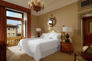 Un dormitorio con una gran cama blanca y una ventana en The Westin Excelsior, Florence en Florence