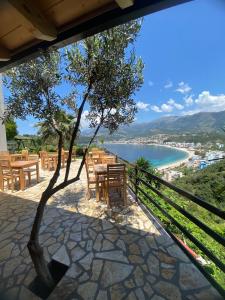 希馬拉的住宿－Hotel Mesun Himare，一个带桌椅的庭院,享有海滩美景