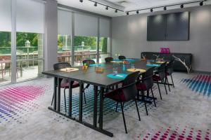 アッシュビルにあるAloft Asheville Downtownの大きなテーブルと椅子付きの会議室を利用できます。