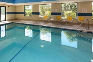 Fairfield Inn & Suites Des Moines West في ويست دي موينز: مسبح بمياه زرقاء وكراسي صفراء