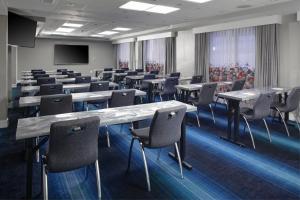 a conference room with tables and chairs and a screen at Aloft Nashville West End in Nashville