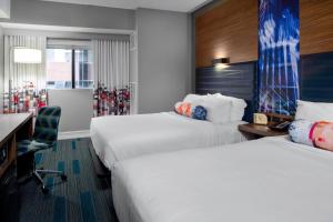 a hotel room with two beds and a desk at Aloft Nashville West End in Nashville