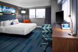 a hotel room with a bed and a desk with a computer at Aloft Nashville West End in Nashville