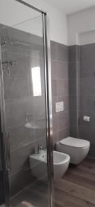 un bagno con doccia in vetro e WC di APPARTAMENTO LECCINO a Malcesine Altre 15 foto