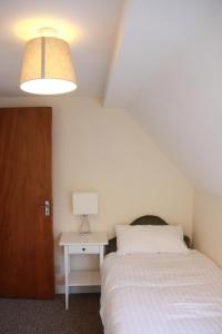 1 dormitorio con 1 cama y 1 mesa con lámpara en Spacious Townhouse, en Youghal