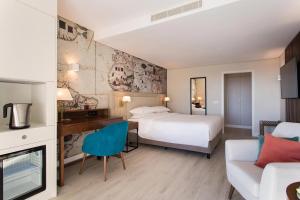 um quarto de hotel com duas camas e um sofá em Four Points by Sheraton Sesimbra em Sesimbra