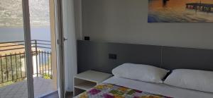 una camera da letto con un letto e vista su un balcone di APPARTAMENTO LECCINO a Malcesine