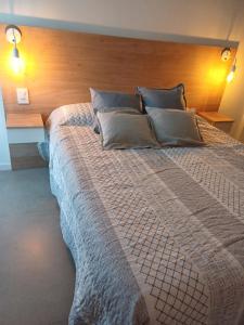 um quarto com uma cama grande e uma cabeceira em madeira em Apart Playa Grande em Mar del Plata