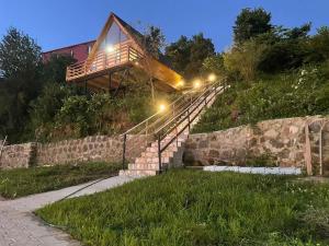 a house on a hill with stairs and lights at Beautiful Wooden house with seaside views in Batumi