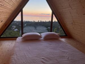 uma cama num quarto com uma grande janela em Beautiful Wooden house with seaside views em Batumi