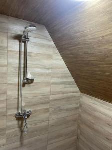 a shower with a shower head in a bathroom at Beautiful Wooden house with seaside views in Batumi