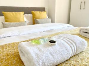 łóżko z białymi kocami i ręcznikami w obiekcie 8 Margaret Road, Whitley Bay w mieście Whitley Bay