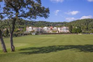 un campo da golf con un albero e edifici sullo sfondo di Denia Marriott La Sella Golf Resort & Spa a Denia