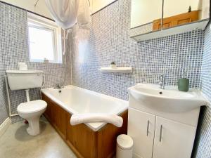a bathroom with a sink and a tub and a toilet at 8 Margaret Road, Whitley Bay in Whitley Bay