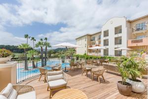 a patio with tables and chairs next to a pool at Denia Marriott La Sella Golf Resort & Spa in Denia