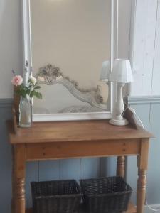 einen Tisch mit einem Spiegel und einer Lampe in der Unterkunft Vine maison 2 bedroom with ensuites in Saint-Julien-dʼEymet