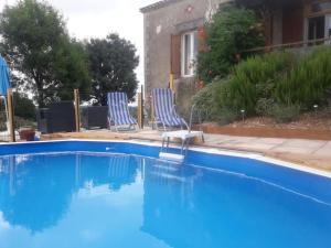 two blue chairs sitting next to a swimming pool at Vine maison 2 bedroom with ensuites in Saint-Julien-dʼEymet