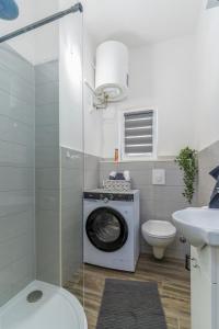 a washing machine in a bathroom with a toilet and a sink at Stunning apartment in quiet street near center With free parking 4 floor in Rijeka