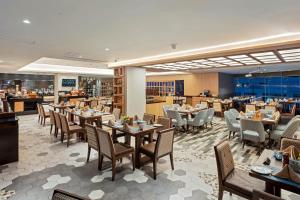 un comedor con mesas y sillas y un restaurante en Four Points by Sheraton Navi Mumbai, Vashi, en Navi Mumbai