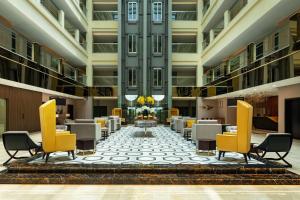een hotellobby met tafels en stoelen en een grote lobby bij Four Points by Sheraton Production City, Dubai in Dubai