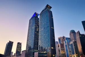 ein hohes Gebäude mit vielen Fenstern in einer Stadt in der Unterkunft Le Méridien City Center Doha in Doha