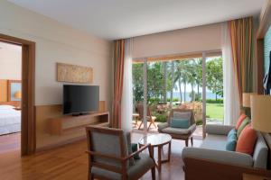 a living room with a television and a room with a bed at Sheraton Hua Hin Resort & Spa in Cha Am