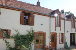 una casa bianca con persiane di legno di Maison Lushbrooks a Moutier-Malcard