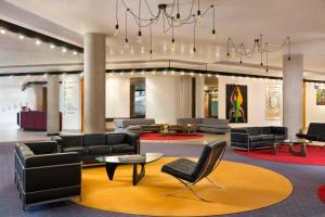 a lobby with couches and chairs and a chandelier at Four Points by Sheraton Catania Hotel in Catania