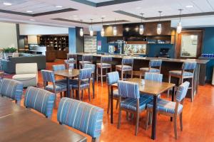 a restaurant with tables and chairs and a bar at Four Points by Sheraton Columbus-Polaris in Columbus