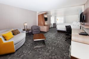 フェニックス・シティにあるCourtyard by Marriott Columbus Phenix Cityのソファとベッド付きのホテルルーム