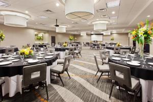 a banquet hall with black tables and chairs and flowers at Courtyard by Marriott Columbus Phenix City in Phenix City