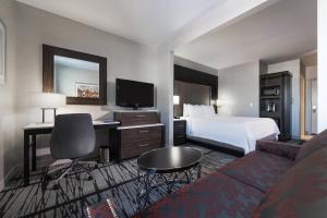 Habitación de hotel con cama y escritorio con TV. en Fairfield Inn & Suites by Marriott Boston Cambridge en Cambridge