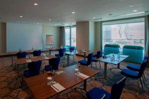 a conference room with tables and chairs and a screen at Four Points by Sheraton Izmir in İzmir