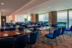 a conference room with tables and blue chairs at Four Points by Sheraton Izmir in İzmir