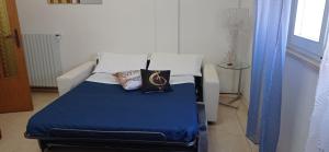 a bed with a blue blanket and pillows on it at Casa Vacanze Ale e Gio in Piombino