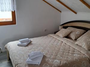 1 dormitorio con 1 cama con 2 toallas en Kuca za odmor Šušnjar, en Ripač