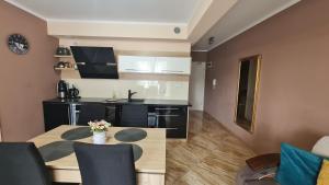 a kitchen and living room with a table and chairs at Apartment Pegaz & Aqua Marina in Świnoujście