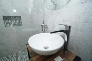 a white sink in a bathroom with a shower at Green Hotel in Abastumani