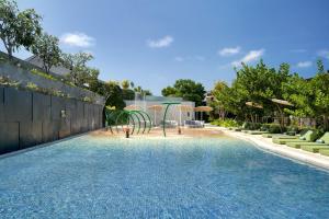 una piscina con parque infantil en un patio trasero en Renaissance Bali Nusa Dua Resort, en Nusa Dua