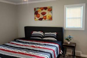 a bed in a bedroom with a painting on the wall at Beautiful 4 bedroom in Euclid in Euclid