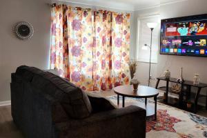 a living room with a couch and a table and a window at Beautiful 4 bedroom in Cleveland in Euclid